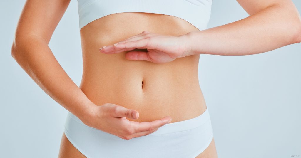 Woman with her hands on their stomach (MODEL)